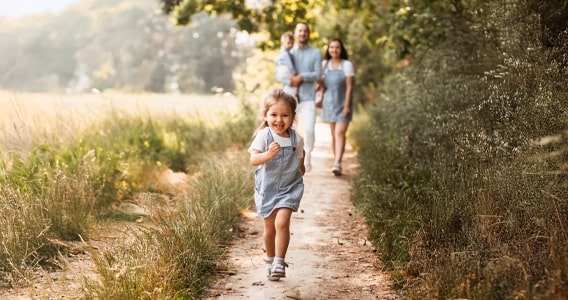 petite fille qui court devant ses parents